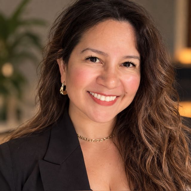 Angie Orduña sonriendo, con saco negro
